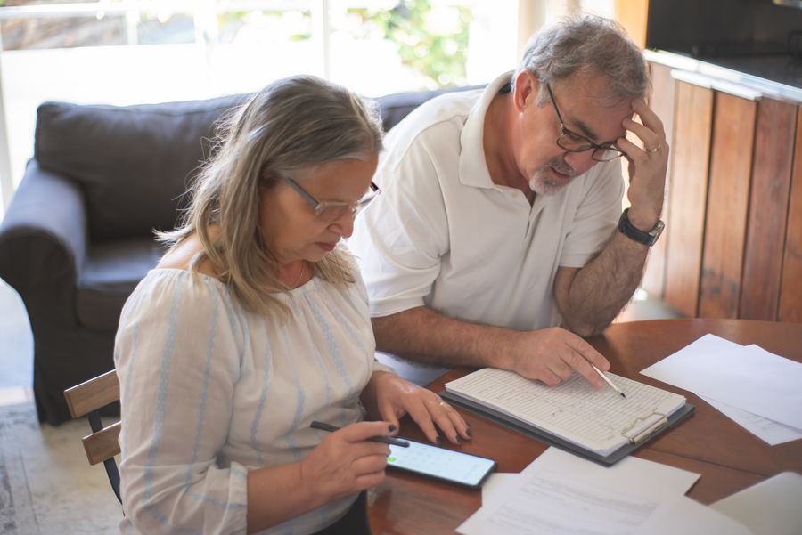 A mature couple reviewing a document and taking notes; illustrative stock photograph.